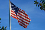 Yhdysvaltojen lippu liehuu voimakkaansinistä taivasta vasten. Lipussa näkyy vasemmassa yläkulmassa sininen alue, jossa valkoisia tähtiä. Lipussa punaisia ja valkoisia vaakasuuntaisia raitoja.