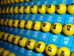 Kuvassa keltaisia bingopalloja sinistä numerotaulua vasten.